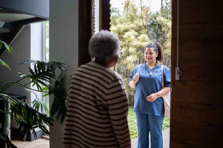 Infirmière à la porte d'une patiente